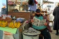 Overweight Georgian man. A street market seller reads a newspaper while sitting at the counter