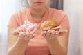 An overweight girl is eating a sandwich and holding a centimeter-long ribbon. Junk food. Selective focus Royalty Free Stock Photo