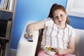 Overweight Girl With Remote Control Eats Junk Food On Couch Royalty Free Stock Photo