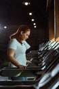 Overweight girl training on treadmill in gym