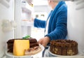 Overweight guy take sausage and cheese from fridge Royalty Free Stock Photo