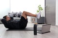 Overweight latino adult man exercises inside his home in his living room via computer online to be healthy