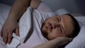 Overweight man in bed trying to fall asleep, health disorder, insomnia, anxiety