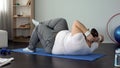 Overweight man doing twisting crunches, pumping abdominal muscles, exercises Royalty Free Stock Photo