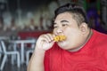 Overweight man eats crunchy fried chicken thighs