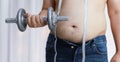 Overweight man exercising by lifting weight with a dumbbell Royalty Free Stock Photo