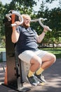 Overweight man exercising on equipment outdoors Royalty Free Stock Photo