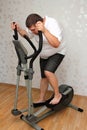 Overweight man exercising on trainer Royalty Free Stock Photo