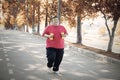 Overweight man jogging with dumbbells at autumn Royalty Free Stock Photo