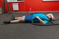 Overweight man is lying on the floor exhausted after performing battle rope exercise in the fitness gym Royalty Free Stock Photo