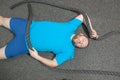 Overweight man is lying on the floor exhausted after performing battle rope exercise in the fitness gym Royalty Free Stock Photo