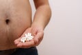 Overweight man with obese belly taking slimming pills. Copy spac