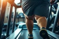 Overweight man runs on treadmill in gym