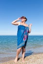 Overweight middle-aged woman in pareo against the sea