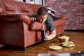 overweight obese boy is drinking carbonated sweet water beverage lying on sofa