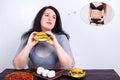 Overweight obese woman eating hamburger and dreaming of fit and