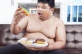 Overweight person eating donuts