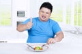 Overweight person with salad and OK sign
