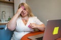 Overweight Plus-Size young blonde woman touching head by hand, pain or headache or stress depression problems with