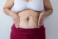 Overweight senior woman pinching her fat body,Cellulite,squeezing her belly fat around her belly button,Healthy lifestyle concept Royalty Free Stock Photo