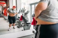 Overweight sweaty woman against mirror in gym