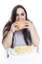 Overweight woman with appetite greedily eats hamburger. Obesity and fast food. Isolated on white background. Vertical Royalty Free Stock Photo