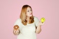 Overweight woman with apple fruit and donuts Royalty Free Stock Photo