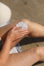 overweight woman applying sunscreen lotion on her legs with varicose veins, close up detail. vacation on sea beach Royalty Free Stock Photo