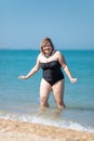 Overweight woman in black one-piece swimsuit at the sea Royalty Free Stock Photo