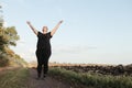 Overweight woman celebrating rising hands to sky