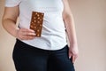 Overweight woman with chocolate bar
