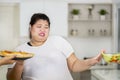 Overweight woman choosing pizza and refuse salad Royalty Free Stock Photo