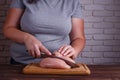 Overweight woman chopping up chicken breasts, close up. Dieting, Royalty Free Stock Photo