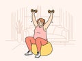 Woman doing sports, wanting to lose weight, lifts dumbbells sitting on inflatable fitness ball Royalty Free Stock Photo