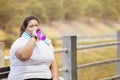 Overweight woman drinking water after exercising Royalty Free Stock Photo