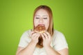 Overweight woman eating donuts in the studio Royalty Free Stock Photo