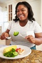 Overweight Woman Eating Healthy Meal in Kitchen Royalty Free Stock Photo