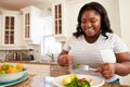 Overweight Woman Eating Healthy Meal in Kitchen Royalty Free Stock Photo