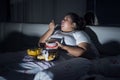 Overweight woman eating junk food in bed before sleeping Royalty Free Stock Photo