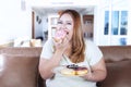 Overweight woman eats donuts Royalty Free Stock Photo