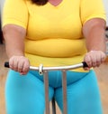 Overweight woman exercising on bike simulator