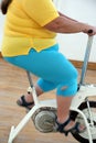 Overweight woman exercising on bike simulator