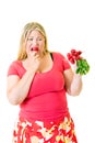 Overweight woman grimacing and eating radishes