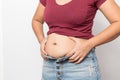 Overweight woman hand pinching excessive belly fat on gray background Healthy concept Royalty Free Stock Photo
