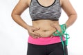 Overweight woman hand pinching excessive belly fat on gray background Royalty Free Stock Photo