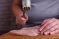 Overweight woman hands beating chicken breasts with meat hammer, Royalty Free Stock Photo