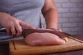 Overweight woman hands chopping up chicken breasts . Dieting, he Royalty Free Stock Photo