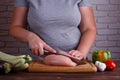 Overweight woman hands chopping up chicken breasts . Dieting, he Royalty Free Stock Photo