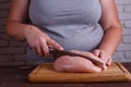 Overweight woman hands chopping up chicken breasts . Dieting, he Royalty Free Stock Photo