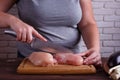 Overweight woman hands chopping up chicken breasts . Dieting, he Royalty Free Stock Photo